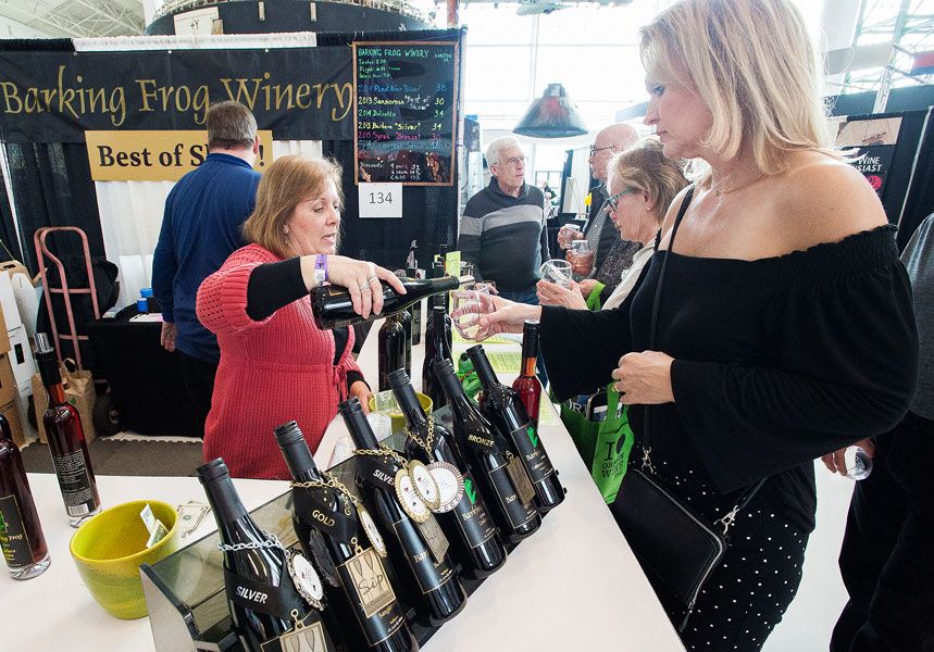 Marcus Larson / News-Register## Cindy Helbig of the Barking Frog winery pours a selection of their 2014 Pinot Noir for patron Diana Treichel during the SIP event at Evergreen Aviation. Barking Frog won top honors in the 2018 Sip awards competition.