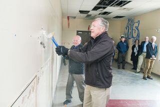 Marcus Larson / News-Register##McMinnville School Board member Tim Roberts and other school officials ceremoniously hammer a wall that will be torn down to make room for new classrooms and a gym at Mac High. Marcus Larson / News-Register##McMinnville School Board member Tim Roberts and other school officials ceremoniously hammer a wall that will be torn down to make room for new classrooms and a gym at Mac High.