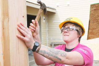 Rockne Roll/News-Register##Liz Hart drives a nail outside what will be the garage of a Habitat for Humanity house Wednesday during their Women Build Project.