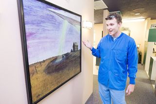 Marcus Larson/News-Register##Dentist Adam
Diesburg shows his painting of an alien ship hovering over a farm - a scene reminiscent of
the famous 1950 Trent
sighting near Sheridan.
Diesburg displays his
artwork on the walls of his
McMinnville dental office.