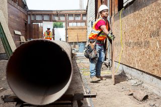 Rockne Roll/News-Register##Dillin Cepeda of Cellar Ridge Construction works to demolish an old breezeway at the former Huberd Shoe Grease Building in McMinnville Wednesday, May 30.