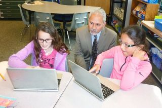 Starla Pointer / News-Register##Salam Noor, state superintendent, watches fourth-graders Jorden Woolen, left, and Nahla Nelson work on their Chromebooks. Noor heard about teaching and learning strategies, encouraging young students to think of college and other topics during his visit to Wascher Elementary. Starla Pointer / News-Register##Salam Noor, state superintendent, watches fourth-graders Jorden Woolen, left, and Nahla Nelson work on their Chromebooks. Noor heard about teaching and learning strategies, encouraging young students to think of college and other topics during his visit to Wascher Elementary.