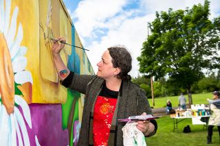 Rusty Rae/News-Register##Mural artist Emily Lux helps paint a mural in Joe Dancer Park along with McMinnville High School art club members.