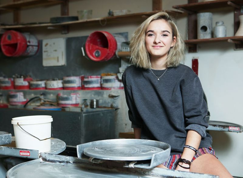 Rockne Roll/News-Register##Mya Clover-Owens sits at the pottery wheel in the McMinnville High School art room. She fell in love with ceramics and other forms of art at Mac High and won a national competition with one of her vases.