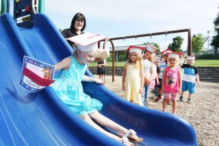 Rockne Roll/News-Register##
Riley Huffman, center, zips down the slide at Joel Perkins Park in Lafayette, symbolizing her graduation from Wascher s preschool program. Each child posed on the slide after receiving a diploma. Rockne Roll/News-Register##
Riley Huffman, center, zips down the slide at Joel Perkins Park in Lafayette, symbolizing her graduation from Wascher s preschool program. Each child posed on the slide after receiving a diploma.