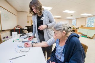 Marcus Larson/News-Register##Volunteer Rachael Krebs checks Shelia Fisher’s blood pressure. Until her visit to the McMinnville Free Clinic, Fisher hadn’t seen a doctor in 20 years. Marcus Larson/News-Register##Volunteer Rachael Krebs checks Shelia Fisher’s blood pressure. Until her visit to the McMinnville Free Clinic, Fisher hadn’t seen a doctor in 20 years.
