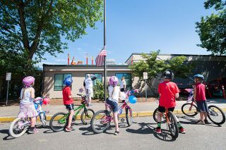 Marcus Larson/News-Register##Hands over their hearts, children observe a brief flag-raising ceremony at Wascher Elementary School before the start of Lafayette’s Fourth of July bicycle parade. Marcus Larson/News-Register##Hands over their hearts, children observe a brief flag-raising ceremony at Wascher Elementary School before the start of Lafayette’s Fourth of July bicycle parade.