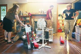 Rockne Roll/News-Register##From right, Nerd Herd robotics team coach Alicia Eagen looks on as Max Kuhn, Meira Lee and Jessica Johnson work on one of the team s robots at Eagan s home in McMinnville. Rockne Roll/News-Register##From right, Nerd Herd robotics team coach Alicia Eagen looks on as Max Kuhn, Meira Lee and Jessica Johnson work on one of the team s robots at Eagan s home in McMinnville.