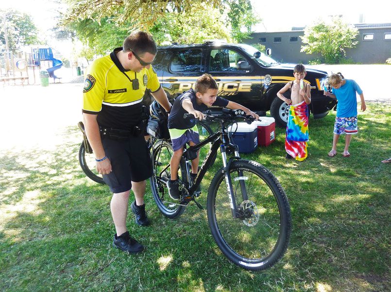 Starla Pointer / News-Register##With help from Officer Tim Jordan, 6-year-old Tanner Rauch checks out one of the Carlton police department s new patrol bicycles. Officers will be able to interact with kids more on the bikes, they said.
