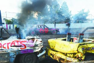 Rusty Rae/News-Register##
Will Tester, winner of the eight-cylinder class at the Demo Derby, gets ready to make a pass at another driver while two smoking hulks of cars are out of action. Rusty Rae/News-Register##
Will Tester, winner of the eight-cylinder class at the Demo Derby, gets ready to make a pass at another driver while two smoking hulks of cars are out of action.