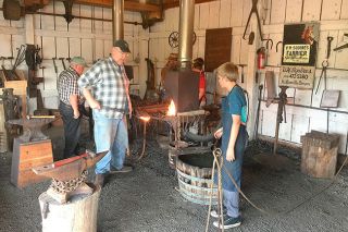Submitted photo##Ike Bay, Dan Bower and other volunteer blacksmiths teach their craft to youngsters at the Yamhill Valley Heritage Center. The smiths will demonstrate their work at Harvest Fest this weekend. Submitted photo##Ike Bay, Dan Bower and other volunteer blacksmiths teach their craft to youngsters at the Yamhill Valley Heritage Center. The smiths will demonstrate their work at Harvest Fest this weekend.