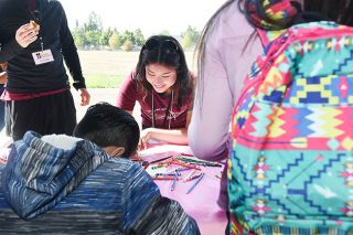 Rusty Rae / News-Register##Linfield student Mara Youngren-Brown helps children write thank-you notes to those who donated to the Beyond Backpack event Saturday at Sue Buel Elementary School. Rusty Rae / News-Register##Linfield student Mara Youngren-Brown helps children write thank-you notes to those who donated to the Beyond Backpack event Saturday at Sue Buel Elementary School.