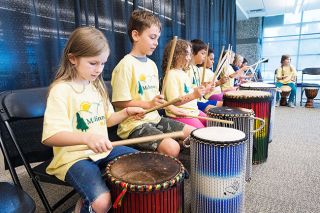 Marcus Larson/News-Register
Meira Pewonka, left, and Cooper Johns, right, along with other third and fourth graders, play a song of peace on the dunun drums during the Rotary Peace Village day camp last week at the Evergreen Aviation & Space Museum. Marcus Larson/News-Register
Meira Pewonka, left, and Cooper Johns, right, along with other third and fourth graders, play a song of peace on the dunun drums during the Rotary Peace Village day camp last week at the Evergreen Aviation & Space Museum.