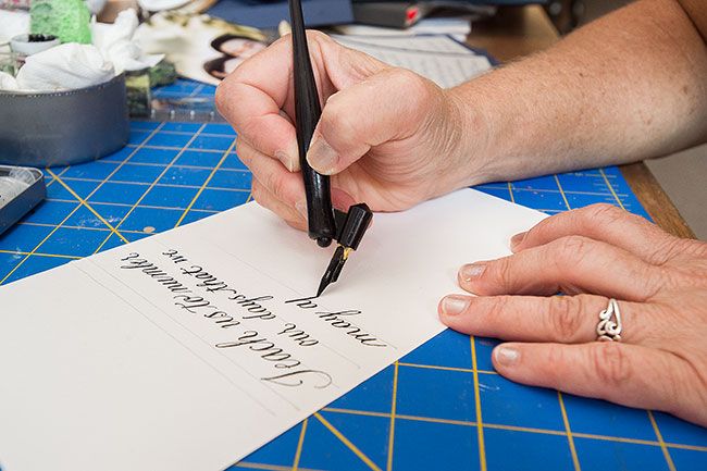 Marcus Larson/News-Register##Newby uses an oblique calligraphy pen that allows her to more easily apply precise amounts of pressure to create thinner or wider strokes.