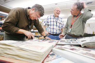Rockne Roll/News-Register##Evergreen Aviation and Space Museum Curator Terry Juran, left, and volunteers Allen Herkamp and Kirk McFarland pore over photo albums that belonged to Arlene Johnsen, a flight attendant killed in the explosion of TWA Flight 800 in 1996. Rockne Roll/News-Register##Evergreen Aviation and Space Museum Curator Terry Juran, left, and volunteers Allen Herkamp and Kirk McFarland pore over photo albums that belonged to Arlene Johnsen, a flight attendant killed in the explosion of TWA Flight 800 in 1996.