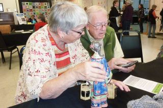 Starla Pointer / News-Register##
Donna and Ron Miller consult the Internet for more information on a delicate porcelin figurine brought to Treasures in the Attic. Starla Pointer / News-Register##
Donna and Ron Miller consult the Internet for more information on a delicate porcelin figurine brought to Treasures in the Attic.