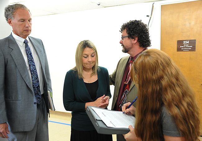 Rusty Rae / News-Register##Attorney Walter Todd stands with his client, Jennifer Weathers, center, as a woman from the pretrial release office explains Weathers  release agreement following her appearance in court Wednesday afternoon.