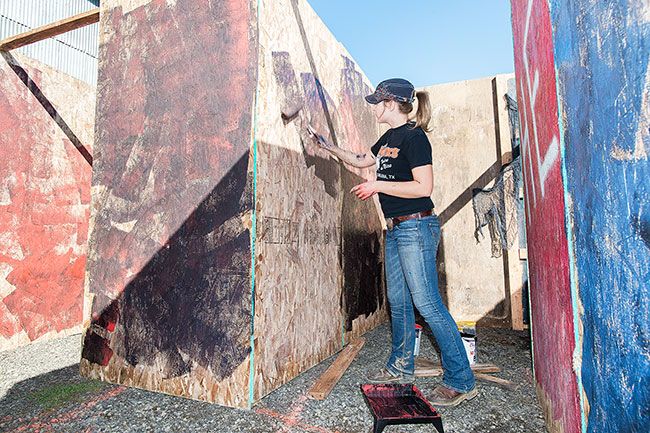Marcus Larson/News-Register##Kaity Scott mixes colors, such as red and black, to add a frantic feeling to the
outside maze. The attraction features indoor and outdoor sections, both equally scary.