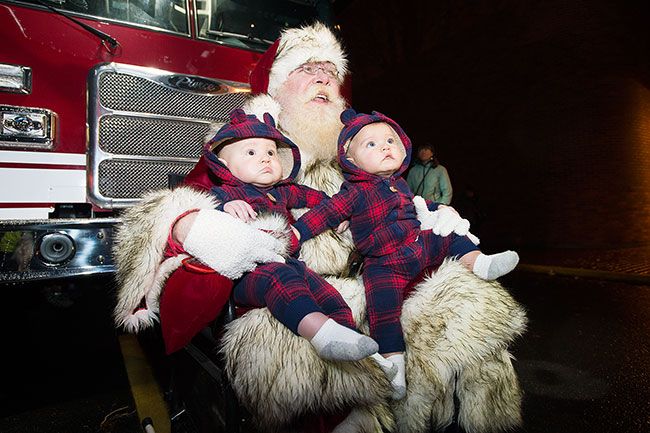 Marcus Larson / News-Register##After the parade, Santa poses with twins Merrick and Ledger Shelton.