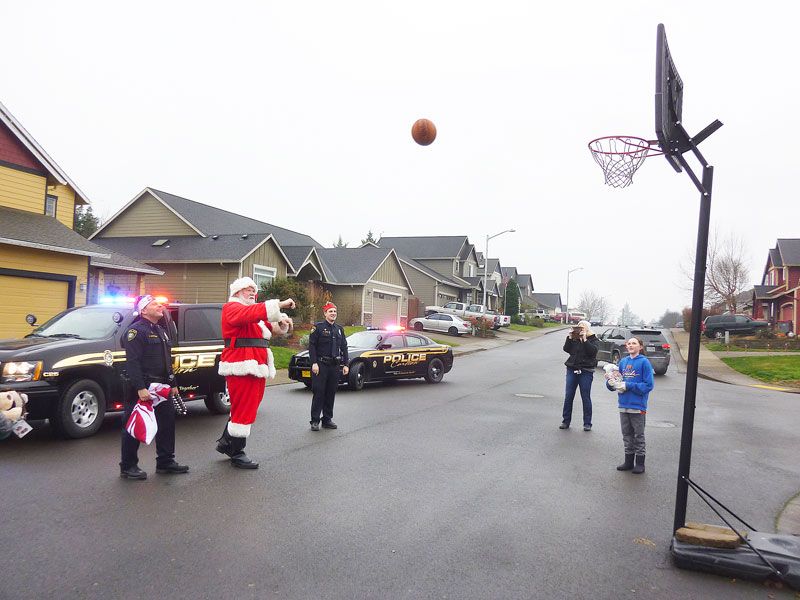 Starla Pointer/News-Register##
Santa and Carlton police officers pause to shoot hoops with youngsters during their holiday patrol. Outscoring Santa means you ll receive coal in your stocking, the man in the red suit joked.