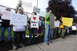 Rockne Roll / News-Register##Protesters stand on Evans Street across from McMinnville High School to protest U.S. Secretary of Education Betsy DeVos visit to the school Wednesday afternoon. Rockne Roll / News-Register##Protesters stand on Evans Street across from McMinnville High School to protest U.S. Secretary of Education Betsy DeVos visit to the school Wednesday afternoon.
