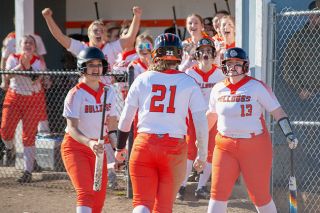 Tanner Russ/News-Register##Willamina softballers celebrate Paisley Deloe as she crosses home plate in the first inning of the season opening clash against Dayton.