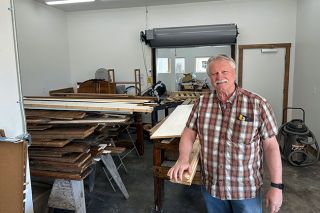 Kirby Neumann-Rea/News-Register##Bill Willis stands with wood from many sources he transforms into art pieces, in the new Earth & Wood studio in Amity. The roll-down door separates the woodworking area and that of the ceramics space used by his son and co-owner, Dan Willis.