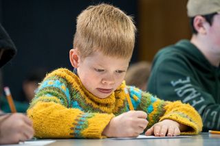 Rachel Thompson/News-Register##Ansel Robertson carefully practices a capital A in cursive — the first letter of his name. He was one of about 20 elementary and middle school students who took Amy Brewer’s class at the McMinnville Public Library.