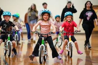 Rachel Thompson/News-Register##Memorial Elementary School kindergartners Hank Anderson, Quincy Oliver and Marley Utti practice balancing as they glide, with their high school helpers walking behind them. The bicycle lessons were initiated by the McMinnville cycling group and a grant from Cycle Oregon. After two weeks at Memorial, the bikes were moved to another elementary school in the McMinnville School District. Rachel Thompson/News-Register##Memorial Elementary School kindergartners Hank Anderson, Quincy Oliver and Marley Utti practice balancing as they glide, with their high school helpers walking behind them. The bicycle lessons were initiated by the McMinnville cycling group and a grant from Cycle Oregon. After two weeks at Memorial, the bikes were moved to another elementary school in the McMinnville School District.