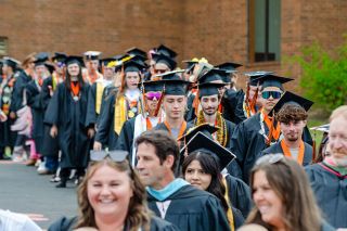 Rachel Thompson/News-Register##Led by their teachers, graduates make their way toward the football field in caps, gowns and colorful regalia during Willamina High School’s commencement ceremony Saturday afternoon. Rachel Thompson/News-Register##Led by their teachers, graduates make their way toward the football field in caps, gowns and colorful regalia during Willamina High School’s commencement ceremony Saturday afternoon.