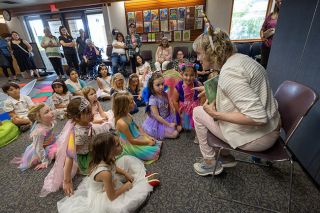 Rachel Thompson/News-Register##Children’s Services Supervisor Kimbre Hanson-Rodriguez reads “Esme the Emerald Fairy and the Search for the Sparkle Stone” to costumed partygoers during Thursday’s fairy-themed event at the McMinnville Public Library. Rachel Thompson/News-Register##Children’s Services Supervisor Kimbre Hanson-Rodriguez reads “Esme the Emerald Fairy and the Search for the Sparkle Stone” to costumed partygoers during Thursday’s fairy-themed event at the McMinnville Public Library.