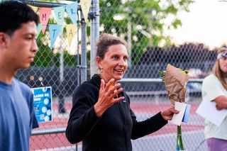 Rusty Rae/News-Register##McMinnville Community Tennis Association Executive Director Lisa Macy-Baker addresses the crowd of local families after being honored with kind words and flowers following the conclusion of the first annual parent-child tennis tournament at the MHS tennis courts on Wednesday, Aug. 20. Mackenzie Fraser, an MCTA instructor and former Linfield player under Macy-Baker, said “It was really cool to stand there and see how many people we have that are interested in tennis in our community. That’s really largely due to (Lisa’s) efforts that we’re able to keep that programming available. She does it out of the goodness of her heart and it was awesome to spotlight her for all her hard work for the last five years.” Rusty Rae/News-Register##McMinnville Community Tennis Association Executive Director Lisa Macy-Baker addresses the crowd of local families after being honored with kind words and flowers following the conclusion of the first annual parent-child tennis tournament at the MHS tennis courts on Wednesday, Aug. 20. Mackenzie Fraser, an MCTA instructor and former Linfield player under Macy-Baker, said “It was really cool to stand there and see how many people we have that are interested in tennis in our community. That’s really largely due to (Lisa’s) efforts that we’re able to keep that programming available. She does it out of the goodness of her heart and it was awesome to spotlight her for all her hard work for the last five years.”