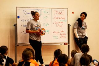 Incoming Yamhill Carlton senior and outside hitter Peyton Gregor holds a tiger-themed volleyball which was given to the camper who most exemplified the mantras and mindsets laid out during the two day camp at the Tiger Dome. YC head coach Jess McGraw stands aside, watching Gregor explain to the group of campers why the player chosen was the most deserving. Behind Gregor, a whiteboard shows the ideas taught to campers that McGraw has passed down from her mothers teachings.##Nathan Ecker/News-Register Incoming Yamhill Carlton senior and outside hitter Peyton Gregor holds a tiger-themed volleyball which was given to the camper who most exemplified the mantras and mindsets laid out during the two day camp at the Tiger Dome. YC head coach Jess McGraw stands aside, watching Gregor explain to the group of campers why the player chosen was the most deserving. Behind Gregor, a whiteboard shows the ideas taught to campers that McGraw has passed down from her mothers teachings.##Nathan Ecker/News-Register