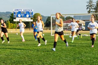 The Amity Warriors girls soccer team runs down the field at Amity High School during a practice session on Monday, Aug. 25. Senior midfielder and twin sisters Adie and Eliza Nisly lead the pack in the foreground of the photo.##Emily Bonsant/News-Register The Amity Warriors girls soccer team runs down the field at Amity High School during a practice session on Monday, Aug. 25. Senior midfielder and twin sisters Adie and Eliza Nisly lead the pack in the foreground of the photo.##Emily Bonsant/News-Register