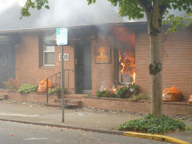 Paul Daquilante / News-Register##About 9 a.m. Tuesday, flames were visible from the interior of the Breathe Body & Spa in a one-story building at 205 N.E. Ford Street.