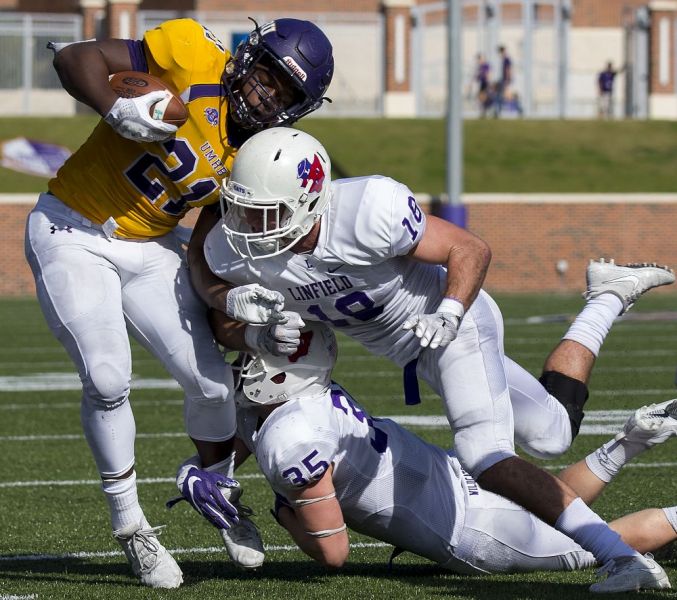 Michael Miller of the Temple Daily Telegram for the News-Register ##
Linfield defenders Jake Reimer (35) and Duke Mackle (18) team up to bring down UMHB s Markeith Miller during the second round contest in Belton, Texas.