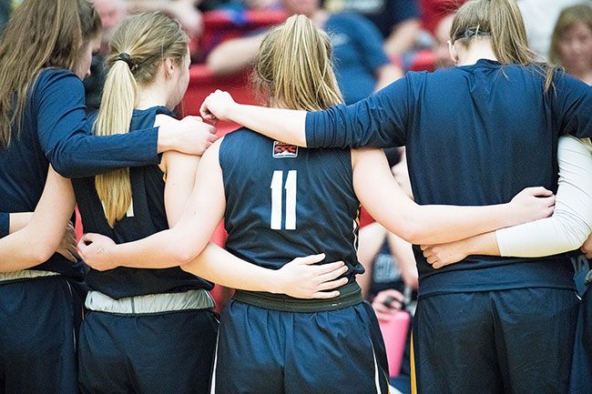 Rusty Rae/News-Register##
Corban point guard Shawnie Spink (11) stands united with her teammates during a timeout of Monday’s contest at Linfield. Spink, a Dayton alum, has earned a starting role for the Warriors one year after suffering an ACL injury. In the recent game, Spink tallied a team-second six points, four rebounds, one steal and one assist. For the year, she is averaging a team-best in assists, while also drilling the most three-pointers for the Warriors.