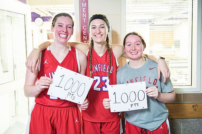 Rusty Rae/News-Register##
Linfield senior forward Kory Oleson (center) joined the 1,000 career point club Monday during a 58-40 win over Corban. Oleson joined teammate Molly Danielson (left) as one of two active and nine total Wildcats to reach the scoring threshold. Freshman Paige LaFountain and Danielson hold up 1,000 point cards for Oleson after her career night.