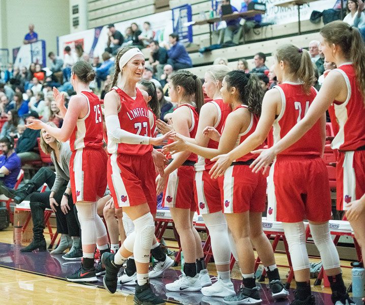 Rusty Rae/News-Register##
Linfield’s Kory Oleson (23) receives high-fives from her teammates following her 21-point effort against Corban Monday, which gave her over 1,000 career points for the Wildcats.