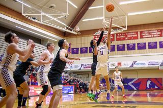 Rusty Rae/News-Register##Linfield’s Trey Bryant (11) puts up a contested shot in the paint during Linfield’s 98-95 OT loss to Willamette on Tuesday. Bryant posted his second career triple double, scoring 14 points and tallying 12 assists and 11 rebounds.