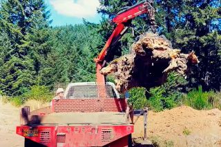 Submitted photo##Mark Pauletto uses his specialized truck and claw to lift a heavy load. The claw is attached to an arm that can reach over fences or debris to grab a load without disturbing its surroundings.