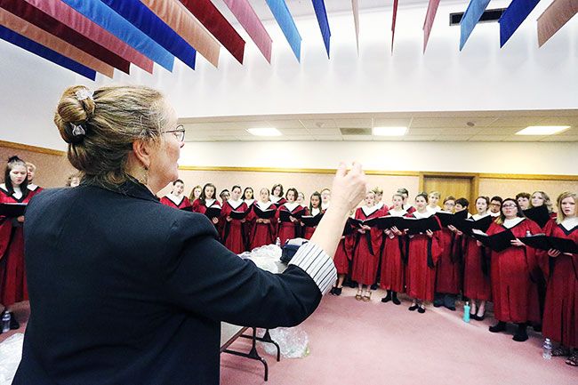 Rockne Roll/News-Register##
McMinnville High School Symphonic Choir director Robin Peterson leads warm-ups prior to the groups s performance at the inauguration.