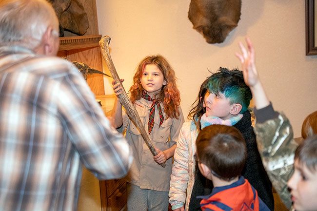 Rusty Rae/News-Register##

River Frisbee holds a piece of mammoth rib up while fossil hunter Mike Full, left, explains that the bone is from an animal that died about 65,000 ago.