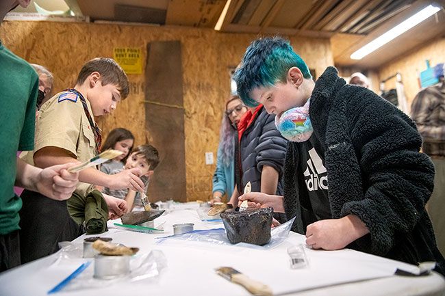 Rusty Rae/News-Register
##
Cub Scout Raen Frisbee , right, applies a water-soluable sealer to a chunk of fossil as fellow Scouts help preserve other ancient bones found along the Yamhill River.