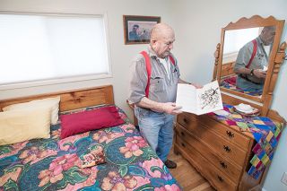 Marcus Larson/New-Register##
Frank Maynard looks through a book by one of his favorite authors — cowboy poet Baxter Black — in a room featuring furniture Maynard built himself.