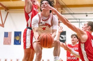 Rusty Rae/News-Register##Willamina’s Cohen Haller shifts around two Kennedy defenders to make a layup during Willamina’s loss on Thursday. Haller finished with 12 points.