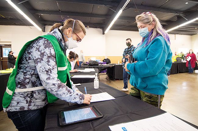 Marcus Larson/News-Register##Adult foster care provider Susan Faulkner checks in with volunteer nurse practitioner Rachel Woolley as part of the pre vaccine protocols.