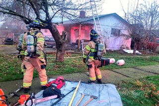 Submitted photo##McMinnville firefighters work to extinguish a blaze on 14th Street.