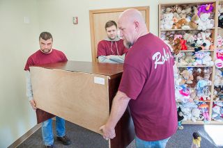 Rusty Rae/News-Register##Volunteers Chris Dabney, Jeremy Barton and Eric Drover of Roby’s Furniture & Appliance move a donated desk into the offices at Juliette’s House. Rusty Rae/News-Register##Volunteers Chris Dabney, Jeremy Barton and Eric Drover of Roby’s Furniture & Appliance move a donated desk into the offices at Juliette’s House.