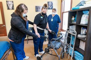 Marcus Larson/News-Register##Caregiver Tiffany Morgan, trainer Melissa Lowe and new caregiver Linda Peterson review the basics of helping people use walkers during a recent training session at Hello Care.